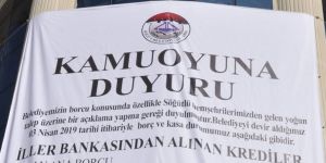Belediyenin borcunu tek tek yazdırıp binaya astı